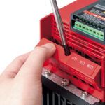 Toshiba VF-NC3 Frequenzumrichter – Hand mit Schraubendreher, sichtbare Anschlussklemmen.